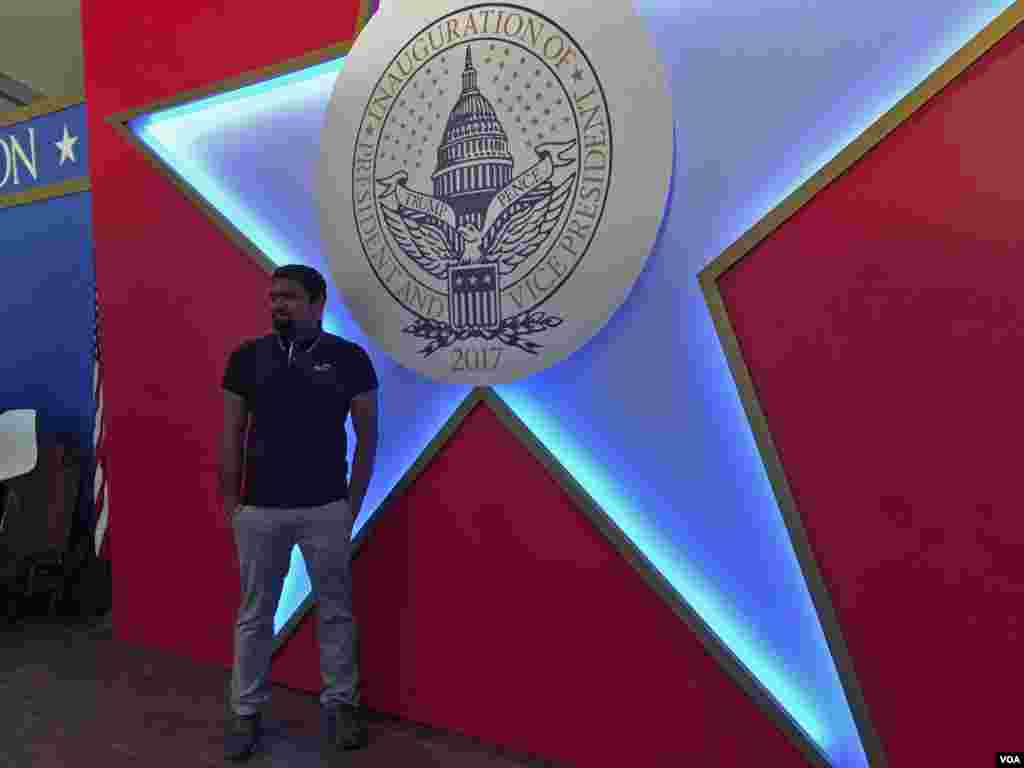 Una persona se toma fotos frente a un símbolo de la Inauguración [Foto: Gesell Tobías, VOA].