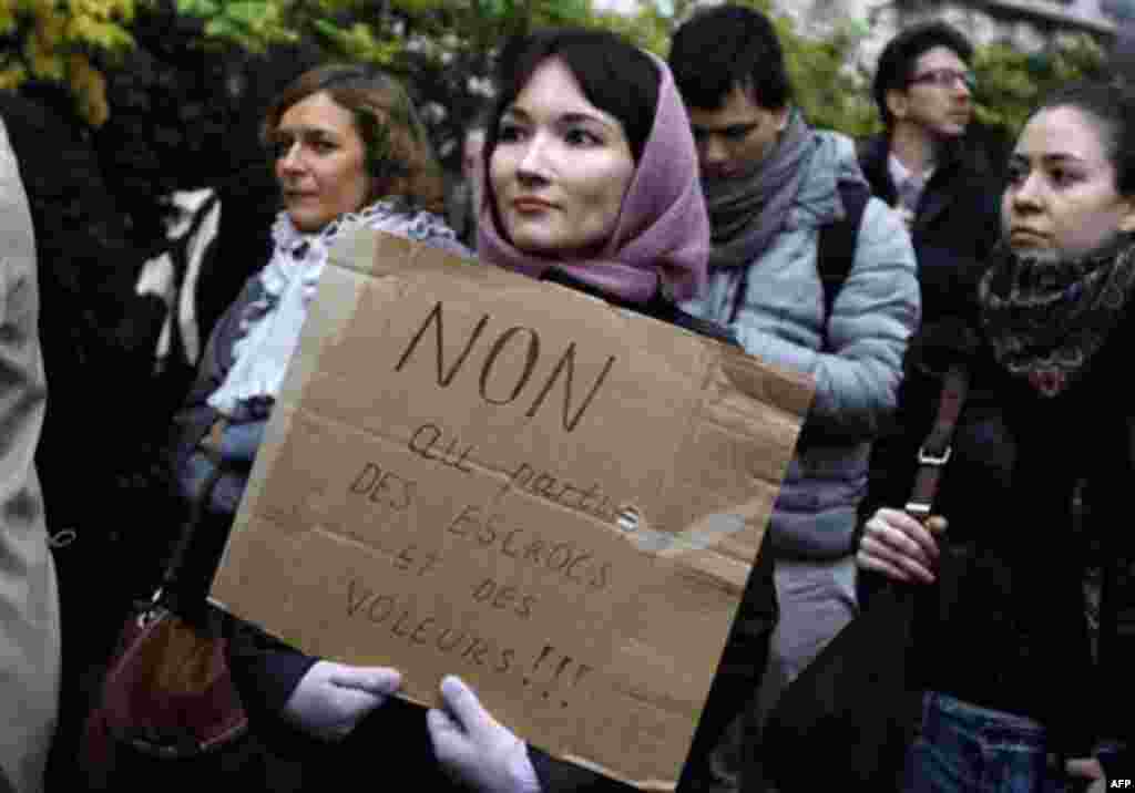 Demonstrators gather in front of the Russian embassy in Paris, Thursday, Dec. 8, 2011, to protest against Russian Prime Minister Vladimir Putin and his party, which won the largest share of a parliamentary election that observers said was rigged. Poster r