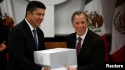 Mexico's Finance Minister Jose Antonio Meade (R) hands over the 2017 budget to the Chamber of Deputies chairman Javier Bolanos in Mexico City, Mexico, Sept. 8, 2016. 