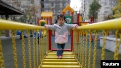 A child walks on a swinging bridge at a kindergarten in Wuhan, Hubei province, December 3, 2012.