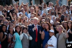 Republican presidential candidate Donald Trump poses for photographs during an campaign event with employees at Trump National Doral, Tuesday, Oct. 25, 2016, in Miami.