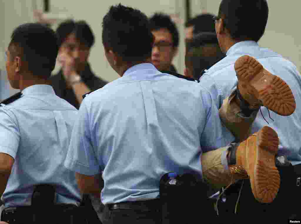 A protester is carried away by police officers after staying overnight in Hong Kong&#39;s financial district, July 2, 2014.