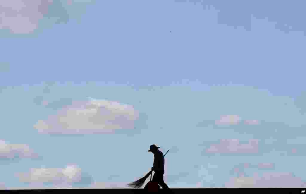 A worker cleans stairs while he is silhouetted at the National Museum of Korea in Seoul, South Korea.