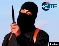 FILE - A masked militant brandishes a knife in this still image from a 2014 video. A new video purportedly shows Islamic State militants beheading three Kurdish peshmerga.