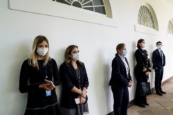 Anggota staf Gedung Putih dan dinas keamana federal Secret Service di lorong West Wing sebelum konferensi pers Presiden Donald Trump mengenai pandemi virus corona, di Gedung Putih, Washington, 11 Mei 2020. (Foto: Reuters)