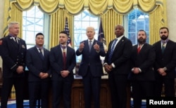 U.S. President Joe Biden stands with recipients after presenting the Medal of Valor in the Oval Office of the White House in Washington, Jan. 3, 2025.