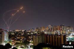 Streaks of light are seen as Israel's Iron Dome anti-missile system intercept rockets launched from the Gaza Strip