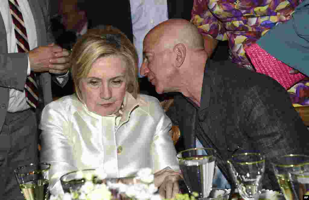 Former Secretary of State Hillary Clinton, left, and Amazon CEO Jeff Bezos chat at the Statue of Liberty Museum opening celebration at Battery Park in New York, May 15, 2019.