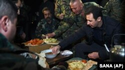 Tổng thống Syria Bashar al-Assad cùng ăn với các binh sĩ khi đi thăm quận Jobar, Syria, 31/12/14