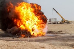 Flames and smoke rise from oil wells inside the Bai Hassan oil field, which was attacked by militants, close to the northern Iraqi city of Kirkuk, May 5, 2021.
