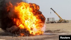 Flames and smoke rise from oil wells inside the Bai Hassan oil field, which was attacked by militants, close to the northern Iraqi city of Kirkuk, Iraq, May 5, 2021. 