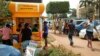 FILE - Ugandans use a mobile money point in Kampala, Uganda, Sept. 29, 2016.