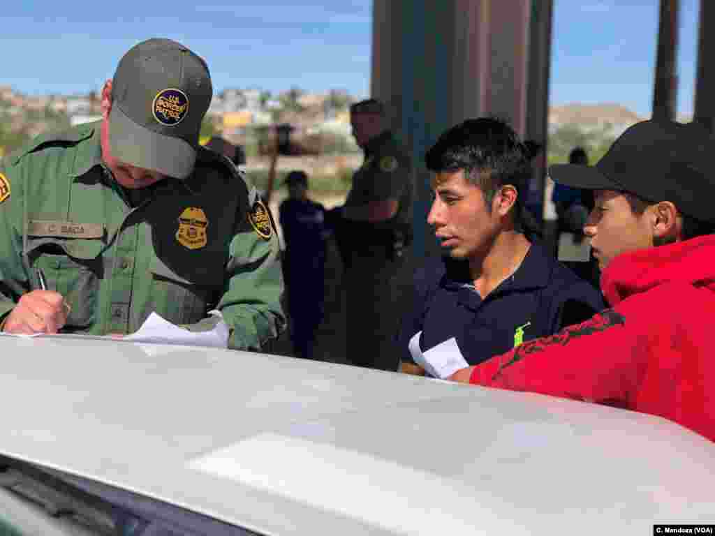 Agent C. Baca processes a group of Guatemalan migrants who turned themselves in to authorities after crossing the U.S.-Mexico border without authorization, at the border between Ciudad Juarez, Mexico, and El Paso, Texas, April 9, 2019.&nbsp;