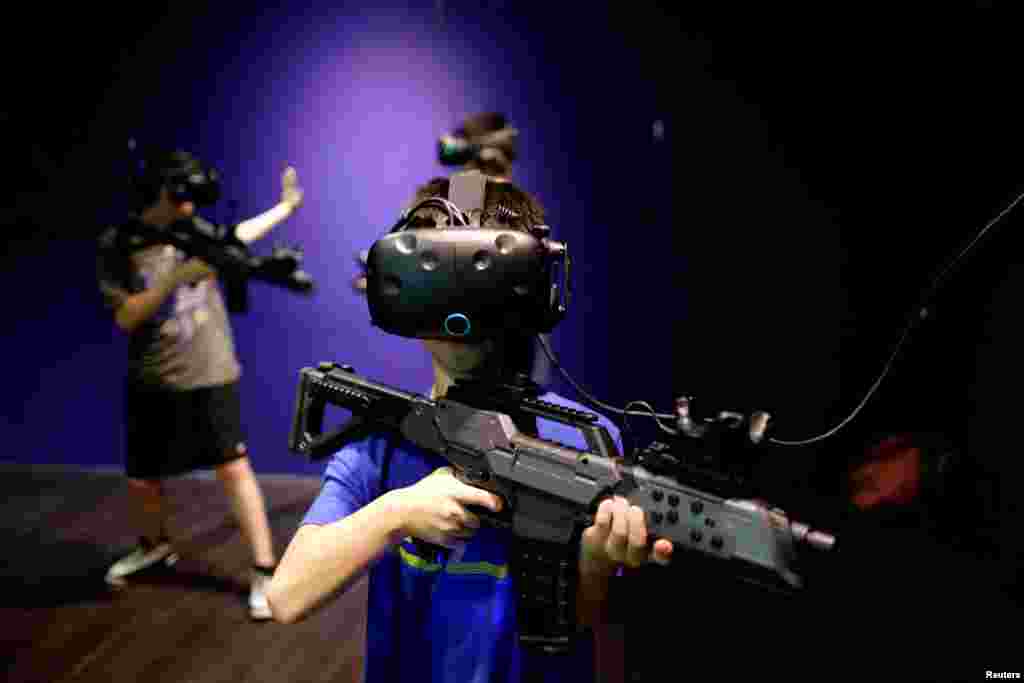 Children wear HTC's Vive Virtual Reality (VR) goggles as they play a VR game at the first Taiwanese VR theme park "Viveland," in Taipei, Aug. 1, 2017.