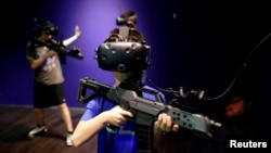 Children wear HTC's Vive Virtual Reality (VR) goggles as they play a VR game at the first Taiwanese VR theme park "Viveland", in Taipei, Taiwan August 1, 2017. 