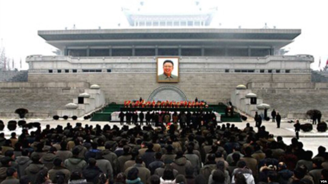 Warga North Korea meletakkan karangan bunga di depan foto besar Kim Jong Il di Pyongyang sebagai penghormatan di tahun baru 2012 bagi mendiang pemimpin mereka (1/1). Foto ini dirilis oleh Sentral Berita Korea dan didistribusikan di Tokyo oleh Kantor Berit