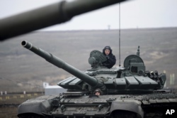 FILE - Russian troops take part in drills at the Kadamovskiy firing range in the Rostov region in southern Russia near its border with Ukraine, Dec. 14, 2021.