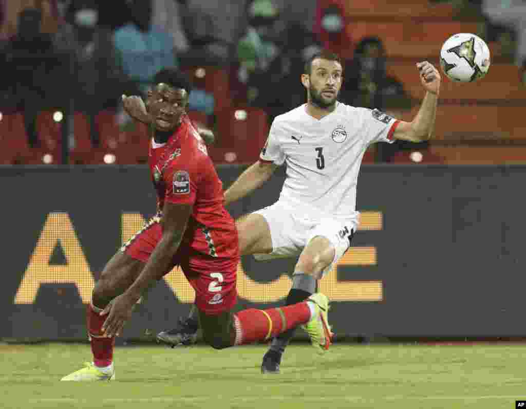 Egypt&#39;s Omar Abdel Wahed, right, and Fali Cande of Guinea-Bissau fight for the ball during the soccer match between Egypt and Guinea-Bissau, Jan. 15, 2022.