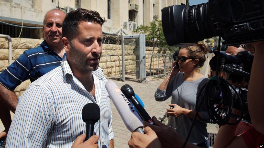 Lebanese father Ali al-Amin speaks to journalists after dropping charges against his estranged wife and an Australian TV crew for attempting to kidnap their children, in front of the courthouse, in the Beirut southeastern suburb of Baabda, Lebanon, Wednes