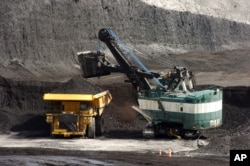 FILE - In this April 4, 2013, file photo, a mechanized shovel loads a haul truck with coal at the Spring Creek coal mine near Decker, Mont.