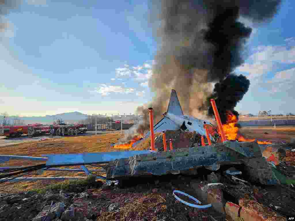 El fuego y el humo se elevan desde la sección de cola de un avión Boeing 737-800 de Jeju Air después de que el avión se estrellara y estallara en llamas en el Aeropuerto Internacional de Muan, en la provincia de Jeolla del Sur, a unos 288 kilómetros al suroeste de Seúl, el 29 de diciembre de 2024.