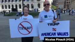 Dua penentang Donald Trump melakukan aksi protes di Cleveland, Ohio Senin (18/7).