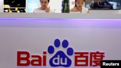 资料照片：在北京举行的中国移动互联网大会（GMIC）期间，员工在百度展台工作。（2018年4月27日）