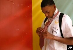 Robert Cooks, a high school freshman, puts on a tie before entering his "Emerging Leaders" class at Chicago's North Lawndale College Prep High School, April 27, 2018.