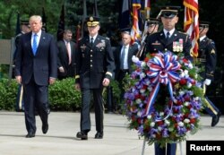US President Donald Trump (L) is escorted for a ceremony to lay a wreath at the Tomb of the Unknown Soldier at Arlington National Cemetery, as part of Memorial Day observance, Arlington, Virginia, May 29, 2017.