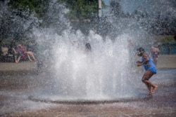 While Portland reached a record temperature of over 110 degrees, June 27, 2021 people gathered at Salmon Street Springs water fountain in Portland to cool off. (Mark Graves/The Oregonian via AP)