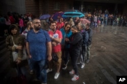 People queue to vote at a school listed to be a polling station by the Catalan government in Barcelona, Spain, Oct. 1, 2017.