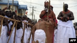 Un aide du palais s'agenouille devant le 40e monarque nouvellement couronné du royaume du Bénin Oba Ewuare II sur un pont en bois lors d'un rite pour marquer son couronnement à Benin City, dans le sud du Nigeria.