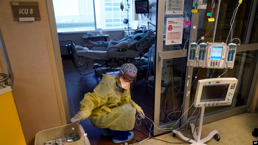 洛杉矶一所医疗中心的一名护士在为重症监护室里的新冠患者整理医疗仪器的电线。（2021年8月17日）(photo:VOA)