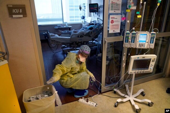 Seorang perawat ICU, memindahkan kabel listrik untuk mesin medis, di luar kamar pasien COVID-19, di unit perawatan intensif Willis-Knighton Medical Center di Shreveport, Louisiana, 17 Agustus 2021..