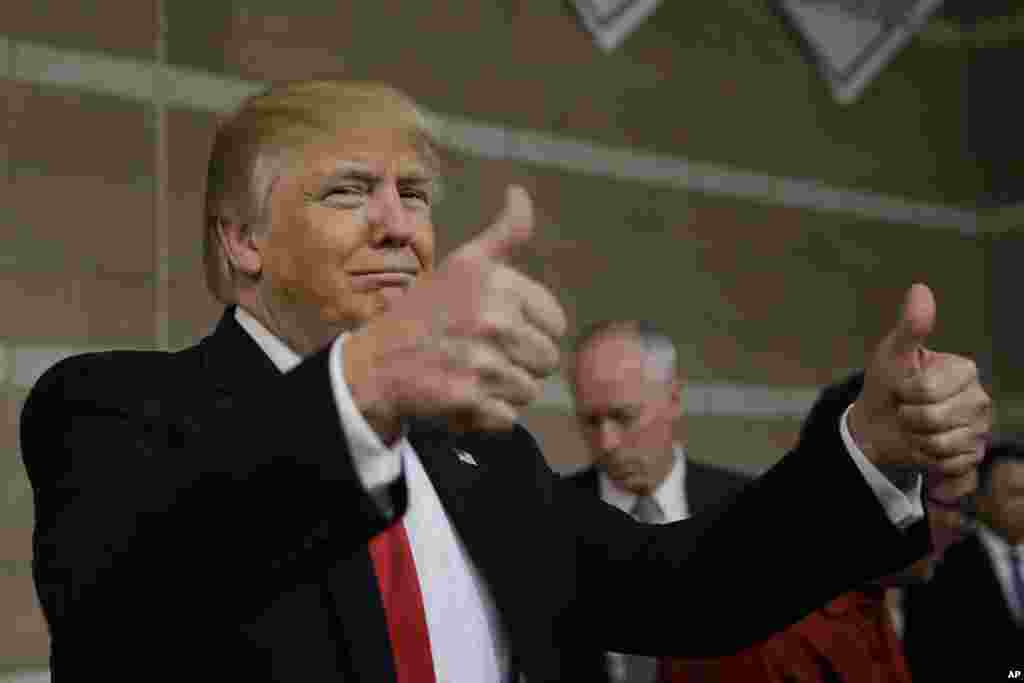 Republican presidential candidate Donald Trump gives thumbs up as he visits a caucus site, Feb. 23, 2016.