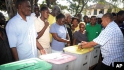 The returning officer for Mvita Constituency, Mombasa, Gabriel Mwalenga, right, explains to registered voters how the ballot boxes will be used in the forthcoming general elections during an election mock voting exercise.