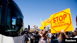 FILE - Demonstrators rally against the arrival of undocumented migrants who were scheduled to be processed at the Murrieta Border Patrol Station in Murrieta, California, July 1, 2014.