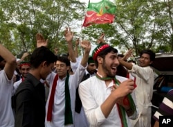 Supporters of politician Imran Khan, chief of the Pakistan Tehreek-e-Insaf party, dance to celebrate the victory of their party candidate, outside their leader's home in Islamabad, Pakistan, Thursday, July 26, 2018.