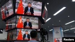 上海举行的中国国际进出口展销会媒体中心的多面电视屏幕正在播放中国领导人习近平的讲话。（2021年11月4日）