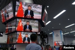 上海举行的中国国际进出口展销会媒体中心的多面电视屏幕正在播放中国领导人习近平的讲话。（2021年11月4日）