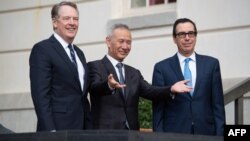 File - US Treasury Secretary Steven Mnuchin (R) and US Trade Representative Robert Lighthizer (L) greet Chinese Vice Premier Liu He (C) as he arrives for trade talks at the Office of the US Trade Representative in Washington, DC, October 10, 2019.