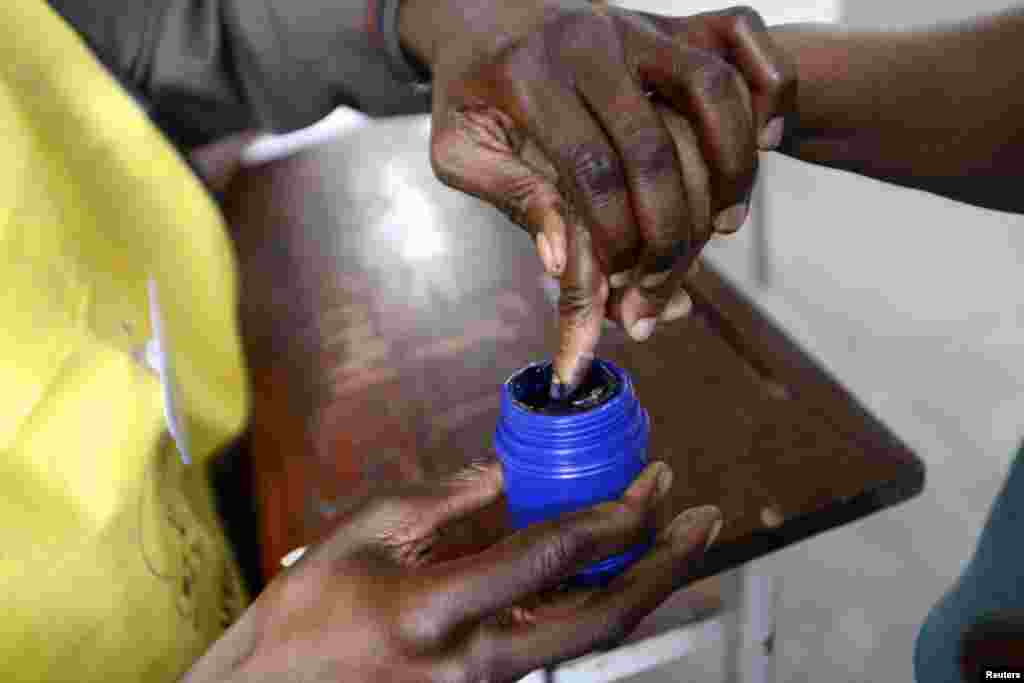 A voter's finger is marked after voting in the general election in Maputo.