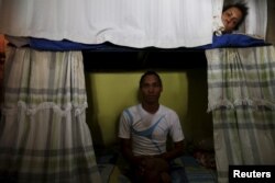 Inmate Alvis Javier (L), poses for a photograph as another prisoner looks from his bunk inside the transgender gallery in La Joya prison on the outskirts of Panama City, Panama, Jan. 27, 2016.