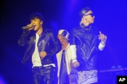 FILE - Korean pop group Big Bang members, from left to right, Seungri, G-Dragon and Taeyang, as they perform in Singapore.
