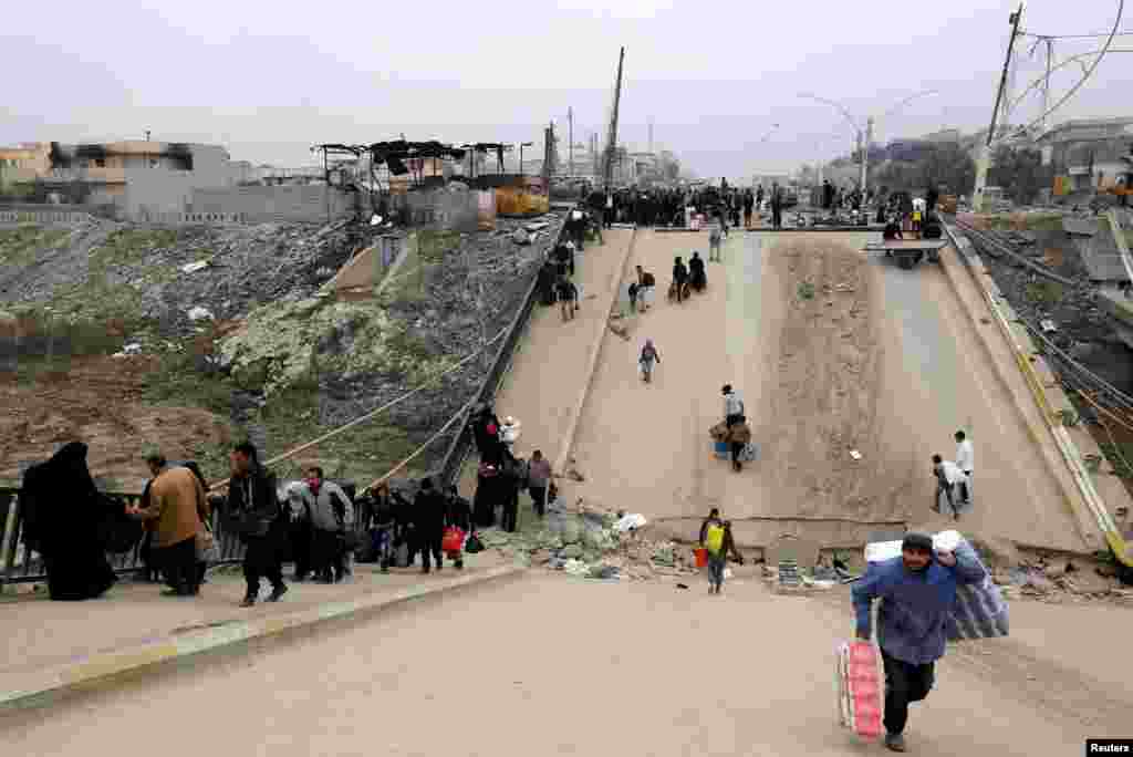 Displaced people, who fled Islamic State militants, cross the bridge in Al-Muthanna neighborhood of Mosul, Iraq, Jan. 15, 2017.