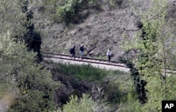 Near the site where 14 migrants were killed by a train, others walk along tracks north of the central Macedonian town of Veles, April 24, 2015.