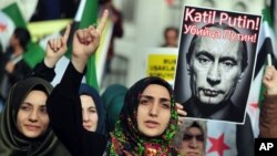 FILE - Turkish protesters shout anti-Russia slogans as they hold a poster of Russian President Vladimir Putin that reads in Turkish and Russian "Assassin Putin!" during a protest in Istanbul, Turkey, Nov. 27, 2015. 