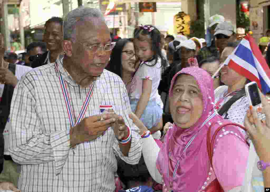 Pemimpin demonstrasi anti-pemerintah Suthep Thaugsuban (kiri) berpose untuk difoto dengan seorang pendukung dalam sebuah demonstrasi di Bangkok, Thailand (8/5). (AP/Apichart Weerawong)