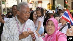 Anti-government protest leader Suthep Thaugsuban, left, poses for a photograph with a supporter during a rally, May 8, 2014 in Bangkok.