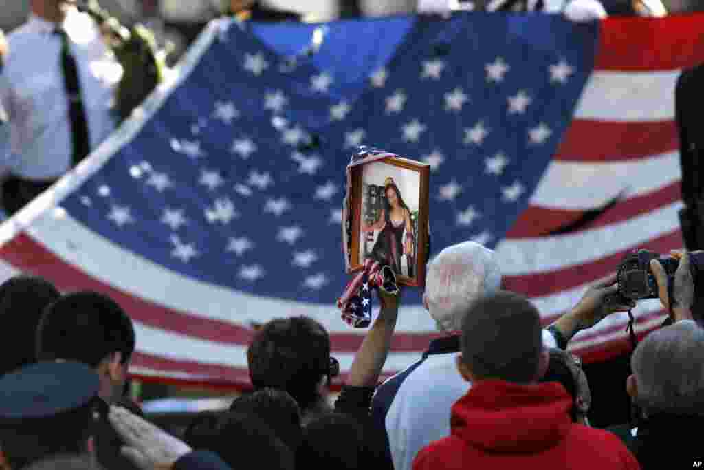 The World Trade Center Flag is presented as friends and relatives of the victims of the September 11, 2001, terrorist attacks, the National September 11 Memorial at the World Trade Center site in New York, September 11, 2012.